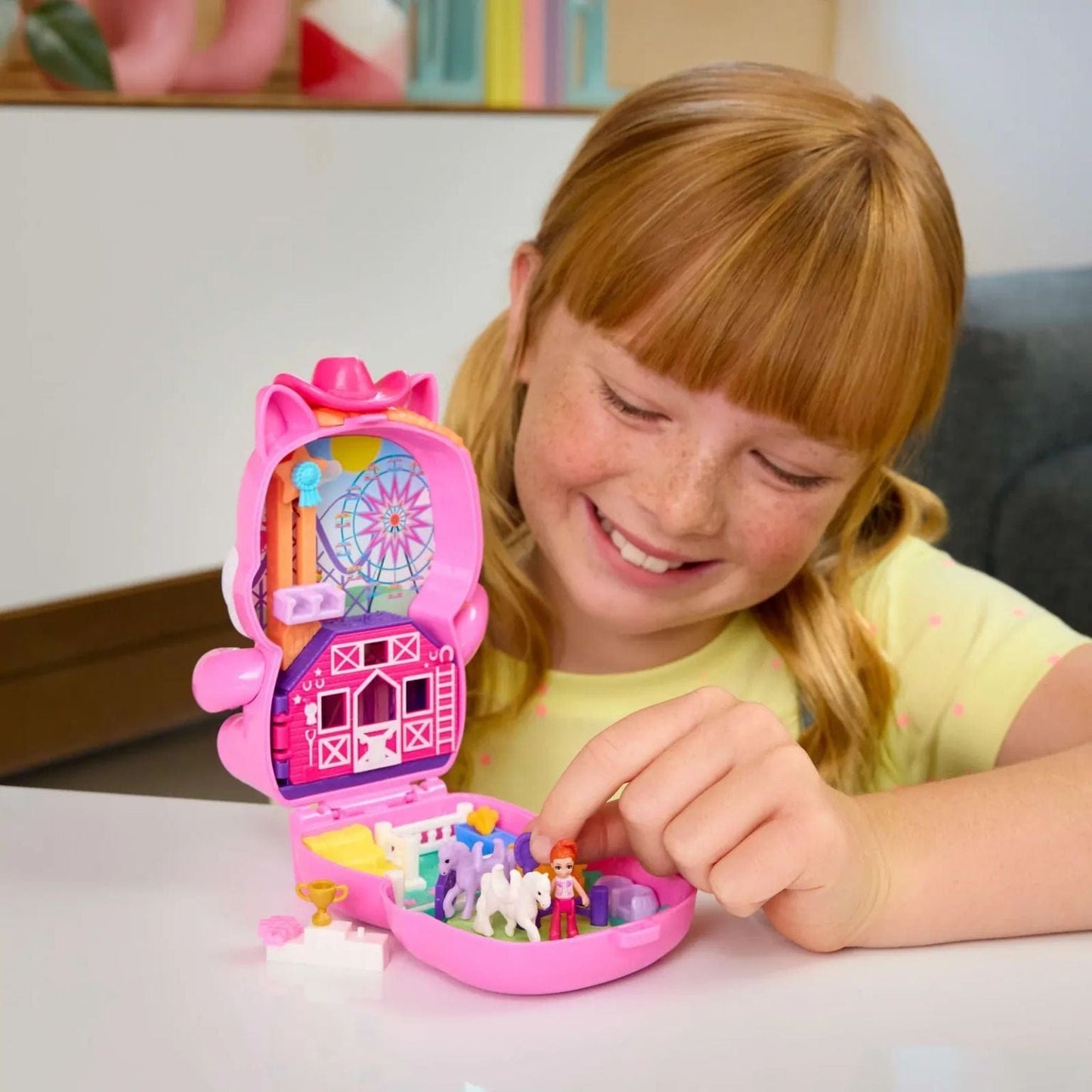 criança a brincar com o compacto Polly Pocket Poney Rodéo com cenário de rodeio e póneis