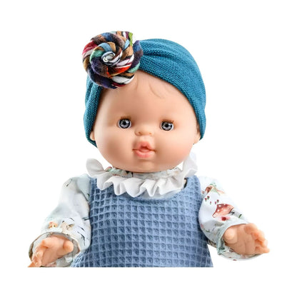 Muñeca Blanca de Paola Reina con ropa azul, cuello blanco y turbante azul con flor colorida