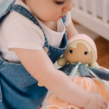 Muñeca de Trapo Chloe Kaloo con vestido suave, chaqueta azul y gorro rosa en estilo delicado para bebé