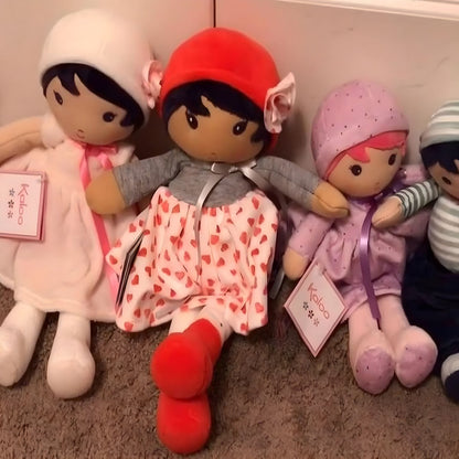 Muñeca de Trapo Jade de Kaloo con vestido blanco de corazones rojos, jersey gris y gorro rojo