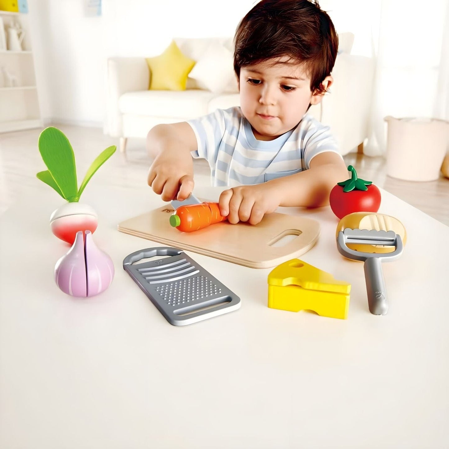 Criança a brincar com conjunto culinária infantil Hape com tábua, legumes e utensílios