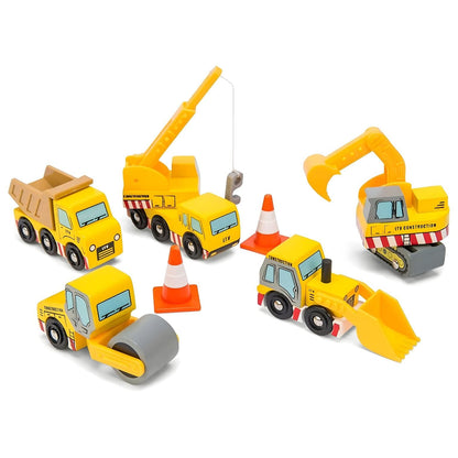 Niño jugando con vehículos de construcción de madera Le Toy Van, incluyendo camión, grúa, excavadora, pala y conos.