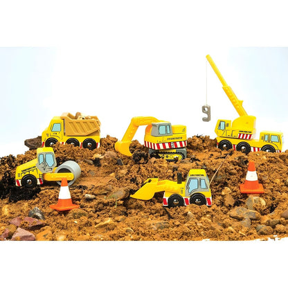 Niño jugando con vehículos de construcción de madera Le Toy Van, incluyendo camión, grúa, excavadora, pala y conos.