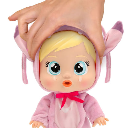 Mão adulta toca na cabeça da Cry Babies Loving Care Angel, que tem lágrimas no rosto