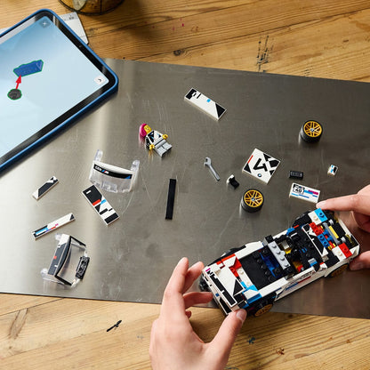 Mãos a montar o Lego BMW M3 (E30) com instruções num tablet