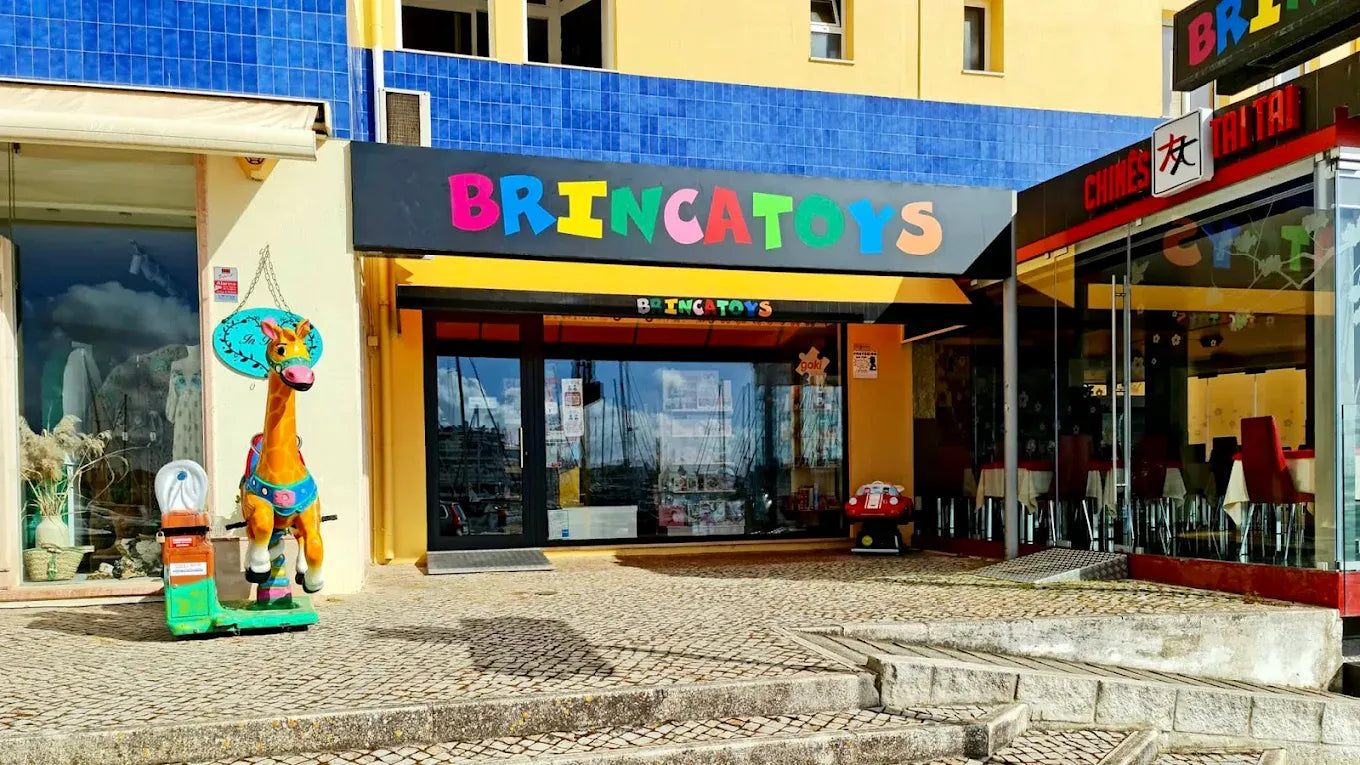 Entrada de la tienda Brincatoys en Vilamoura, con el rótulo de colores y la jirafa junto a la puerta.